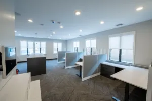 Open-plan office with workstations and gray carpet