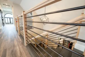 Modern office staircase with wood handrails and black metal balusters