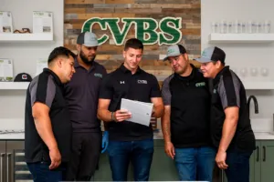 Five CVBS team members reviewing a tablet