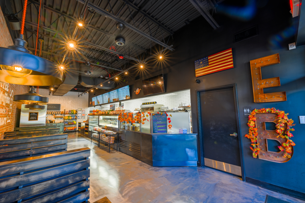 Professionally cleaned dining area at a bagel shop, with view of the food counter