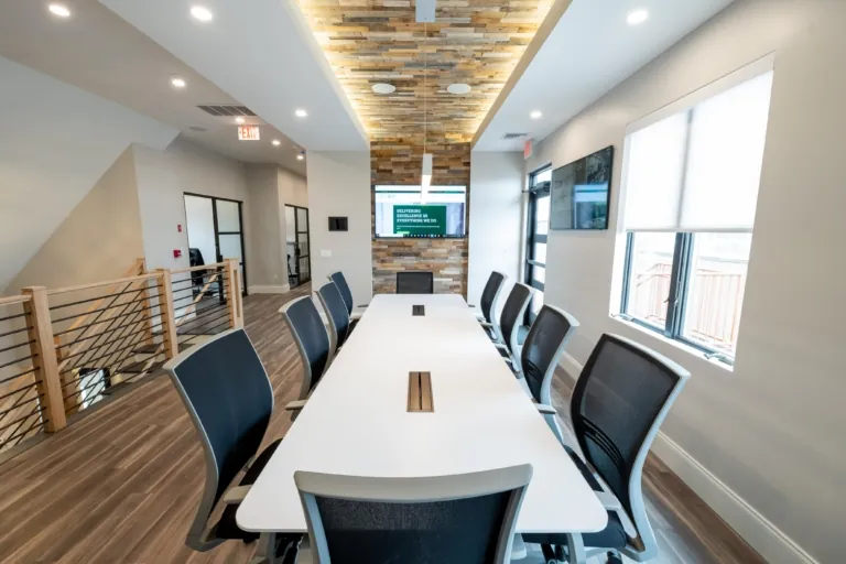 Conference room with a long white table and wood accent ceiling