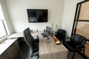 Renovated conference room with table, chairs, and wall-mounted screen
