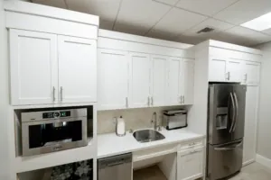 Office kitchenette with white cabinets and stainless steel appliances