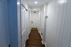 Renovated hallway with blue doors and wood flooring at Timber Point