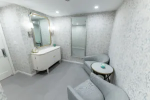 Renovated restroom with vanity, mirror, and lounge seating