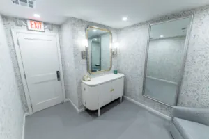 Restroom vanity and mirror beside a tiled shower