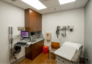 Clean medical exam room with examination table and equipment